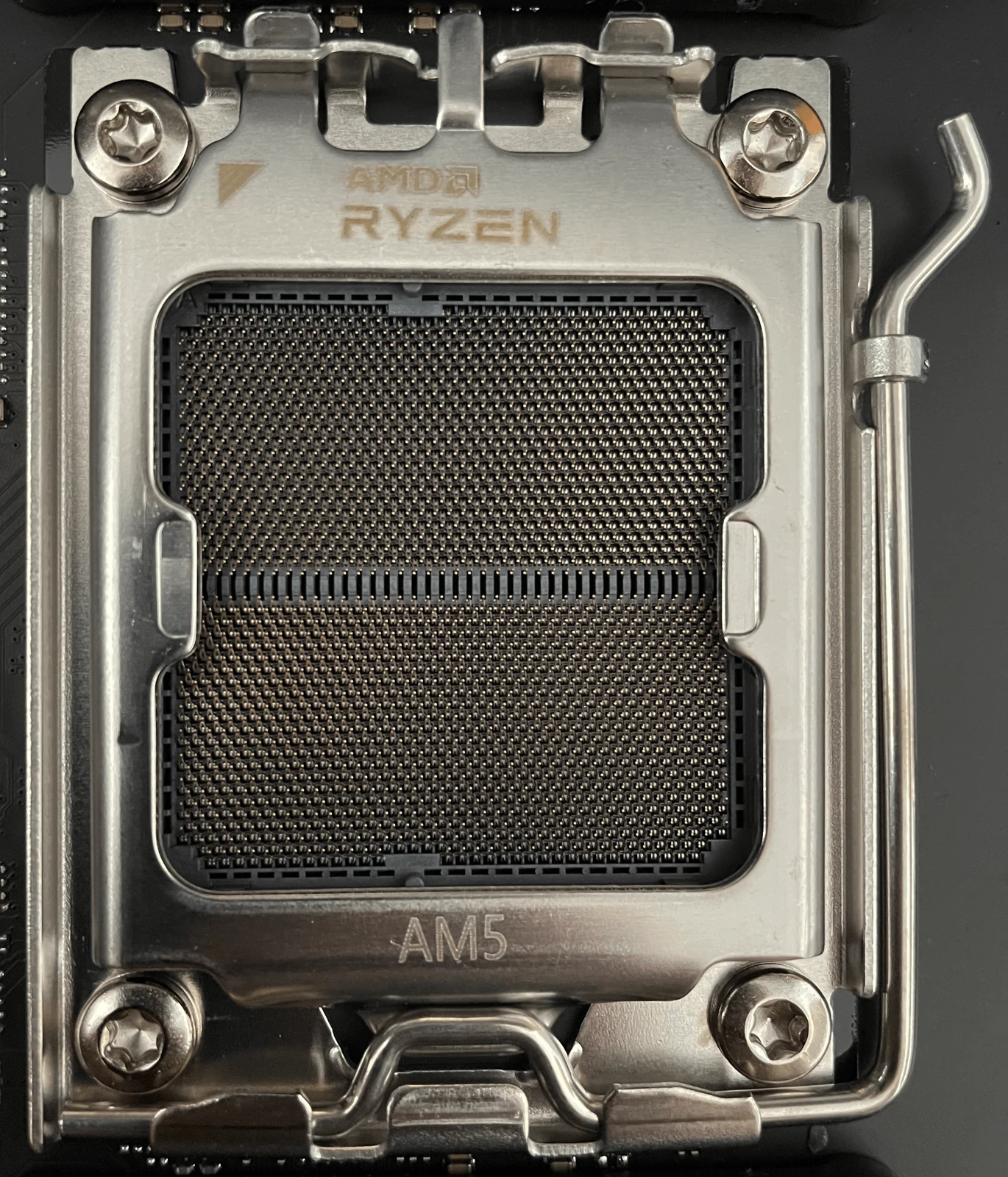 Real close-up photograph of an empty AMD AM5 CPU socket.